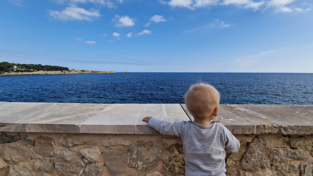 Kleinkind blickt auf das Mittelmeer auf Mallorca